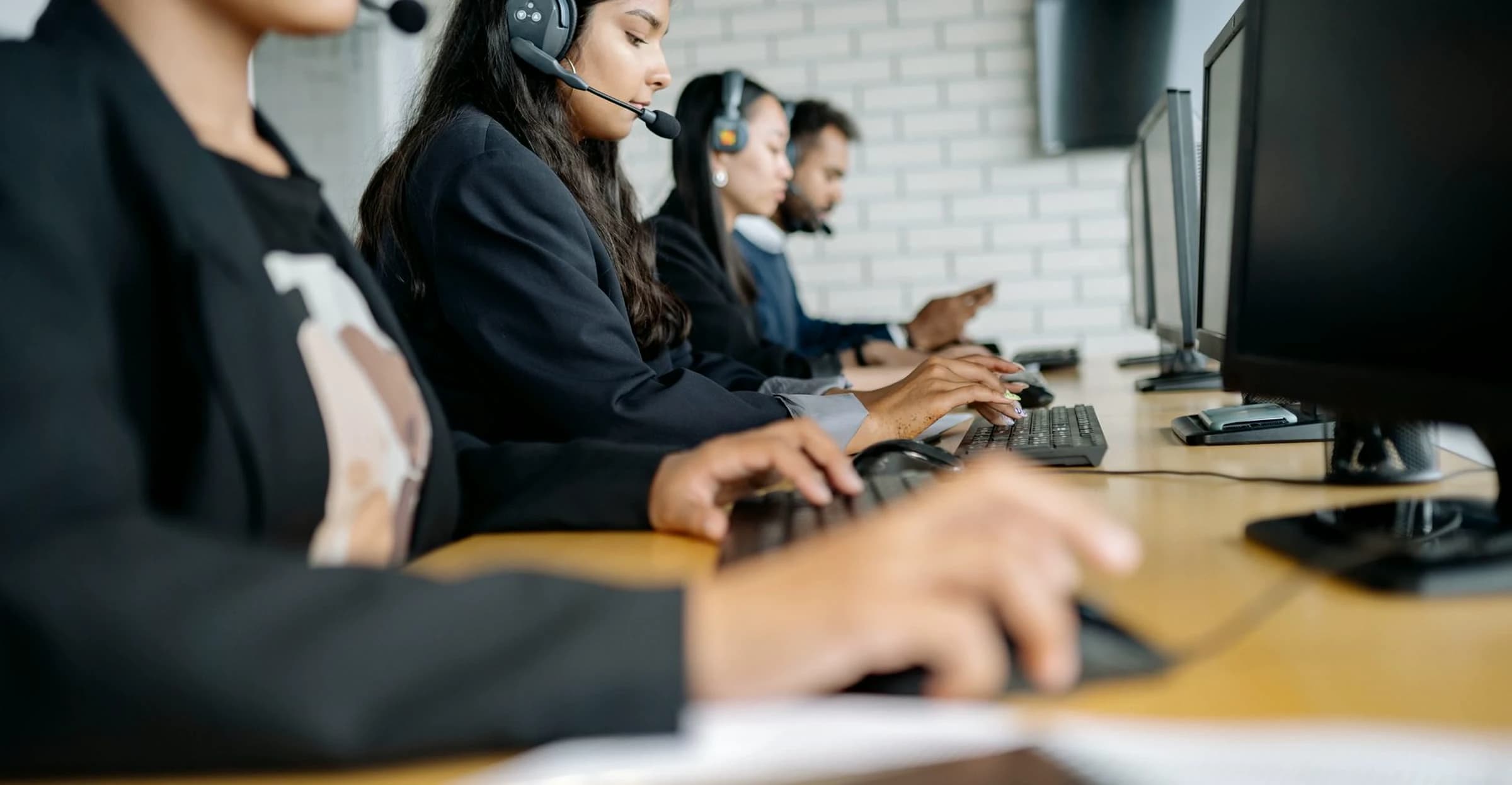 A call-centre floor: agents at a row of desks, working on headsets